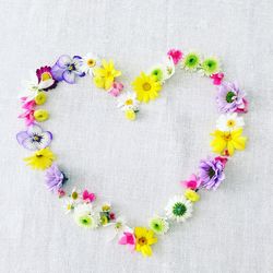 Flowers arranged in heart shape on fabric