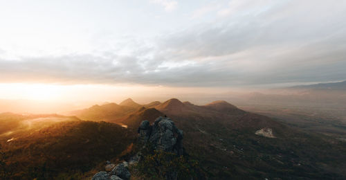 Rear view of man looking at mountains against sky
