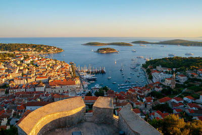 High angle view of townscape by sea against clear sky