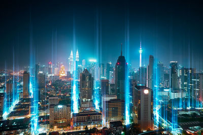 Illuminated cityscape against sky at night