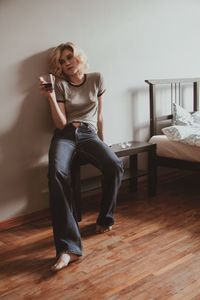 Portrait of young woman sitting on table at home