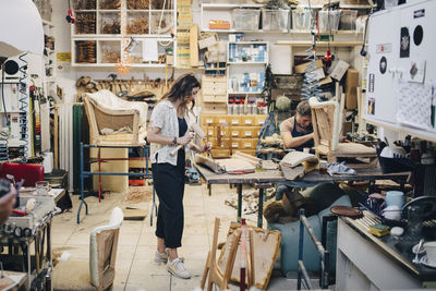 Male and female upholstery workers working in workshop