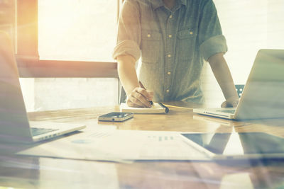 Rear view of woman working on table