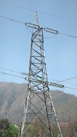 Low angle view of electricity pylon against clear sky