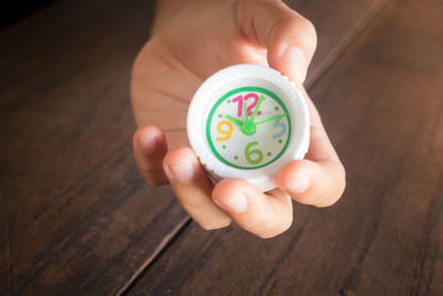 Close-up of hand holding clock