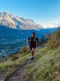 Full length of man running on mountain against sky