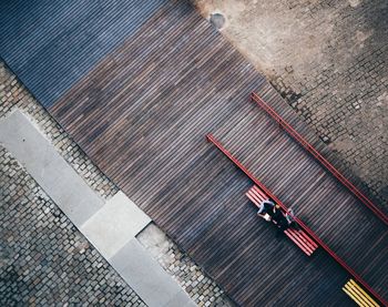 Directly above shot of men sitting on bench at boardwalk