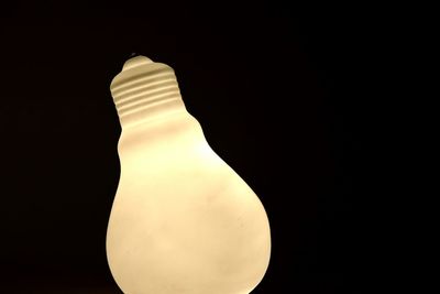 Close-up of illuminated lamp against black background