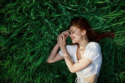 Portrait of young woman sitting on grassy field