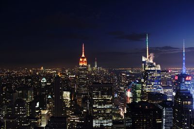 Illuminated cityscape against sky at night