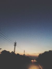 Electricity pylon against sky at sunset