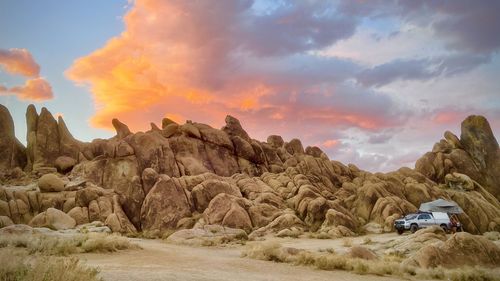 Street amidst rocks against sky during sunset