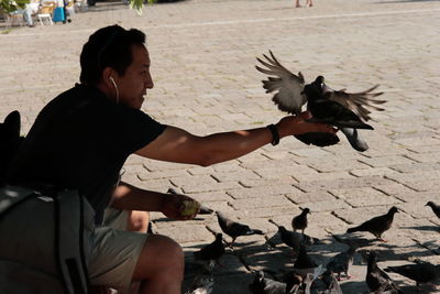 Full length of man feeding birds