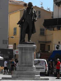 Statue on street against buildings in city