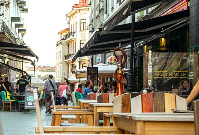 People on street amidst buildings in city