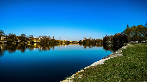 Scenic view of lake against clear blue sky