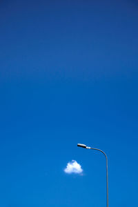 Low angle view of street light against blue sky