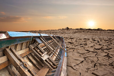 Old fishing boat on the dry cracked ground.