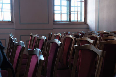 Empty chairs and tables in front of window