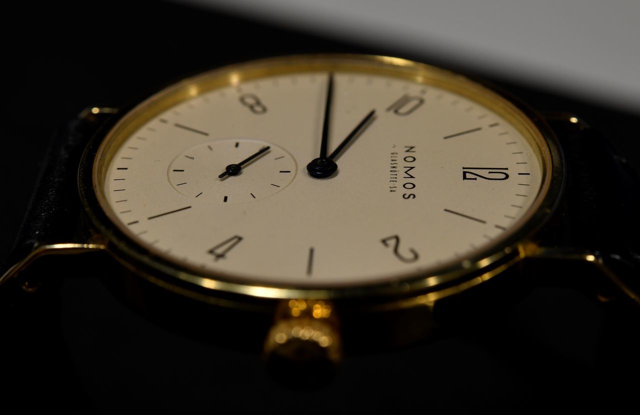 watch, time, clock, hand, instrument of time, close-up, wristwatch, indoors, clock face, studio shot, yellow, number, minute hand, clock hand, accuracy, metal, single object, black background, strap