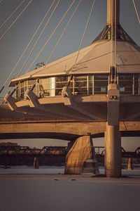 Bridge over river by buildings against sky