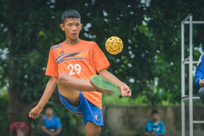 Full length of boy running with ball