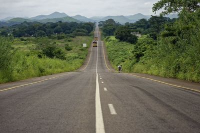 Road amidst green mountains against sky