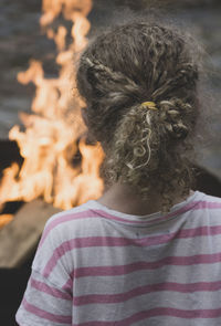 Rear view of girl looking at bonfire