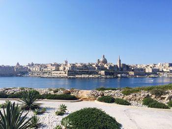 View of cityscape against clear blue sky