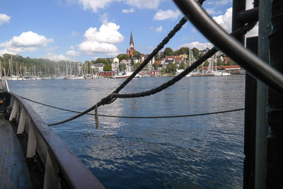 Bridge over river by buildings in city against sky