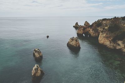 High angle view of rocks in sea against sky