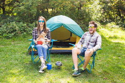 Full length of young couple sitting outdoors