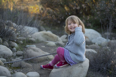 Portrait of girl sitting on rock