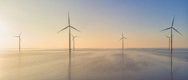 Low angle view of windmills against sky