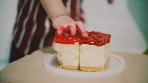 Cropped hand of woman holding cake