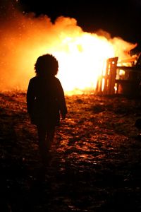 Rear view of a man standing at sunset