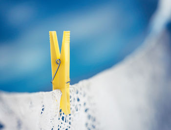 Yellow clothespin on clothesline