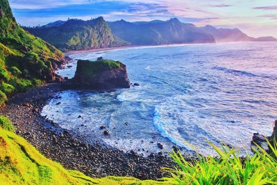 Scenic view of sea and mountains against sky