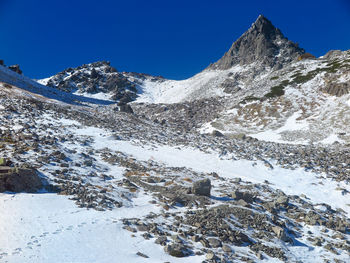 Scenic view of snowcapped mountains against blue sky