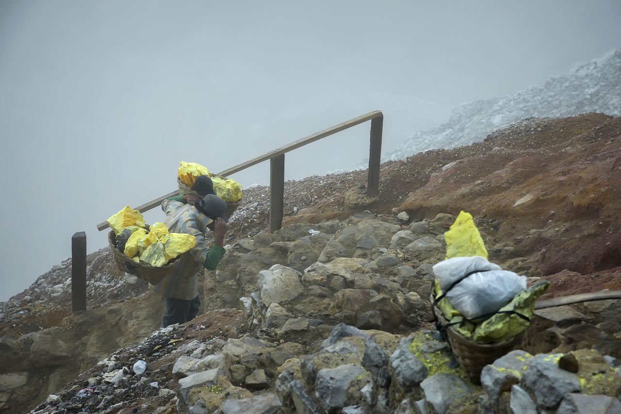 mountain, nature, rock, occupation, men, adult, environment, sky, protection, clothing, helmet, activity, protective workwear, headwear, full length, day, industry, reflective clothing, working, outdoors, adventure, climbing, two people, geology, cold temperature, ridge, beauty in nature, mountaineering, fog