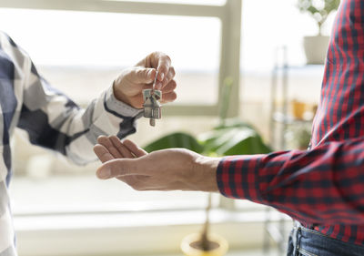 Real estate agent giving house key to new home buyer