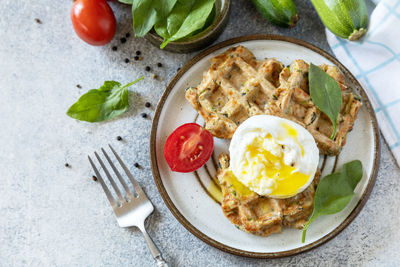 The concept of dietary and healthy breakfast. spinach and zucchini vegan waffles with a poached egg.