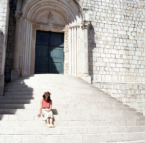 Full length of woman on staircase against building