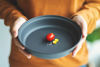 Closeup image of a woman holding a plate of small amount of food for diet concept