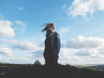 Teenage girl standing against sky