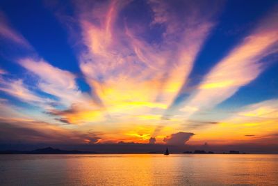 Scenic view of sea against dramatic sky during sunset