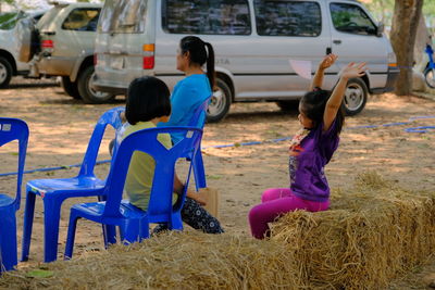 Rear view of children sitting on land