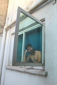 Close-up of woman looking through window