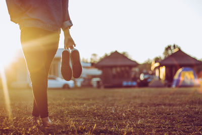 Low section of woman standing on field against sky