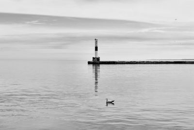 Lighthouse on sea against sky